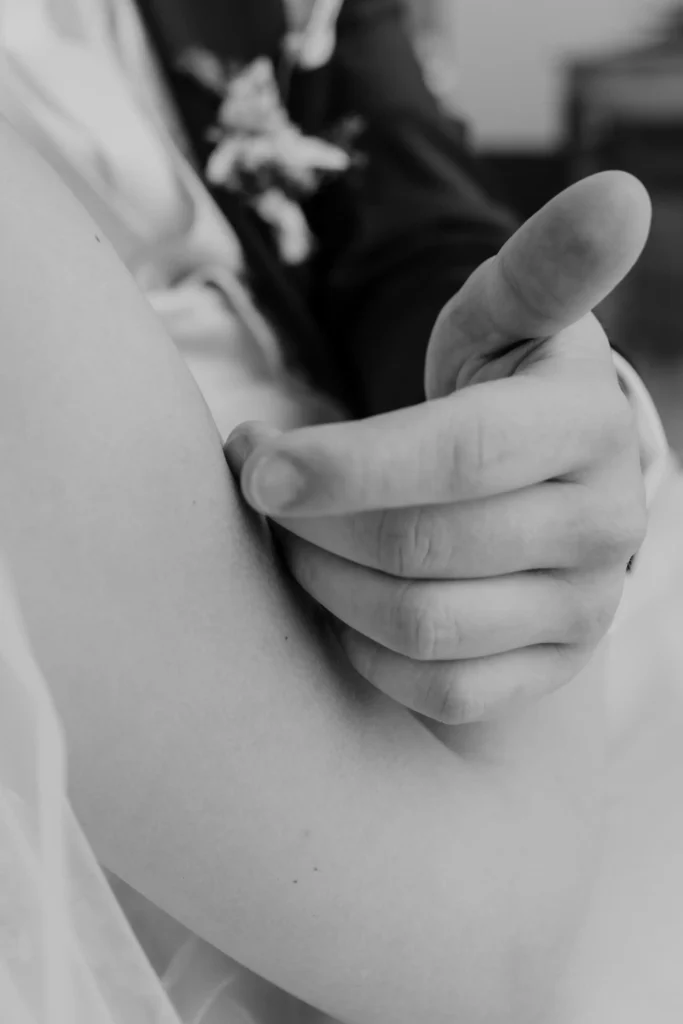 Bräutigam streichelt zärtlich den Arm der Braut